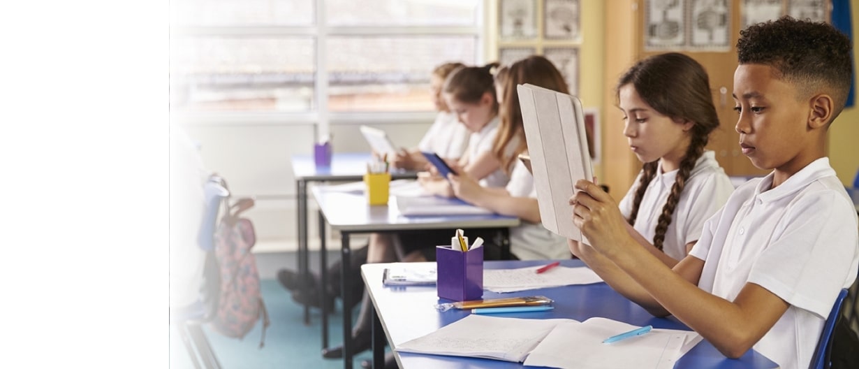 Children in a classroom working on tablets